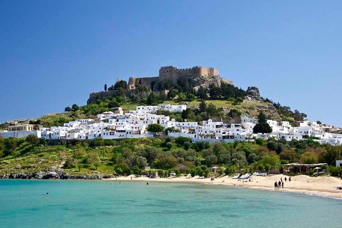 uma vista de uma praia com um castelo em uma colina