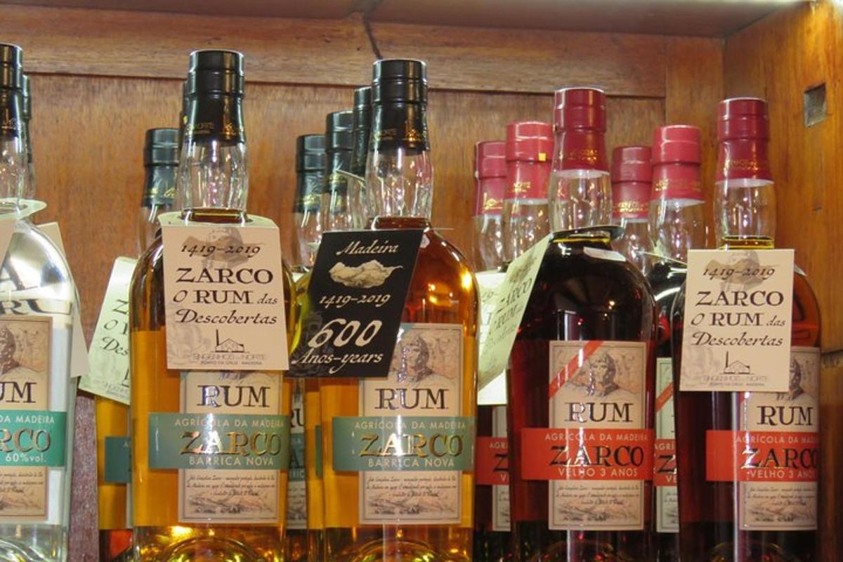 o grămadă de sticle de vin pe un raft cu pahare