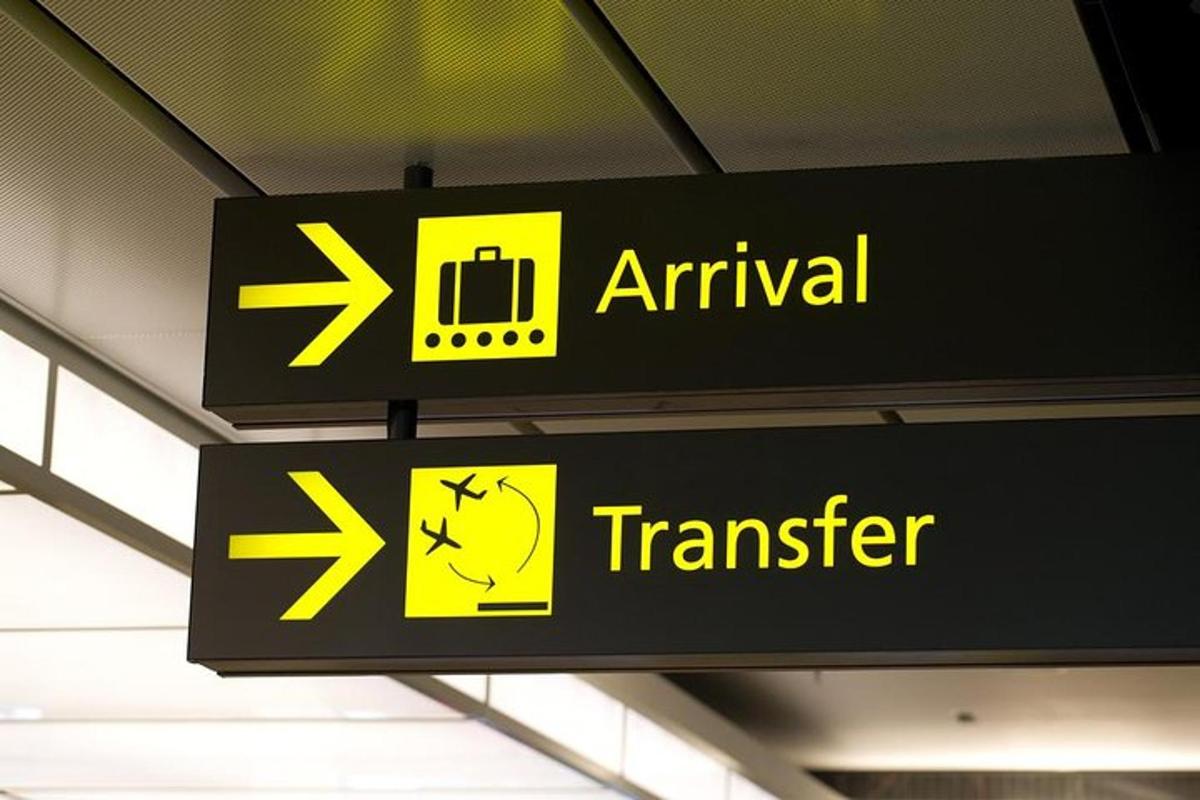 un cartello in un aeroporto con frecce e un treno
