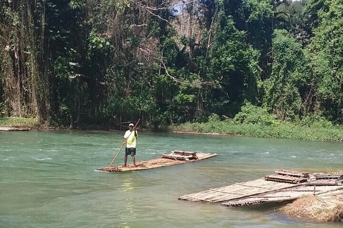 seorang lelaki sedang berdiri di atas rakit di sungai