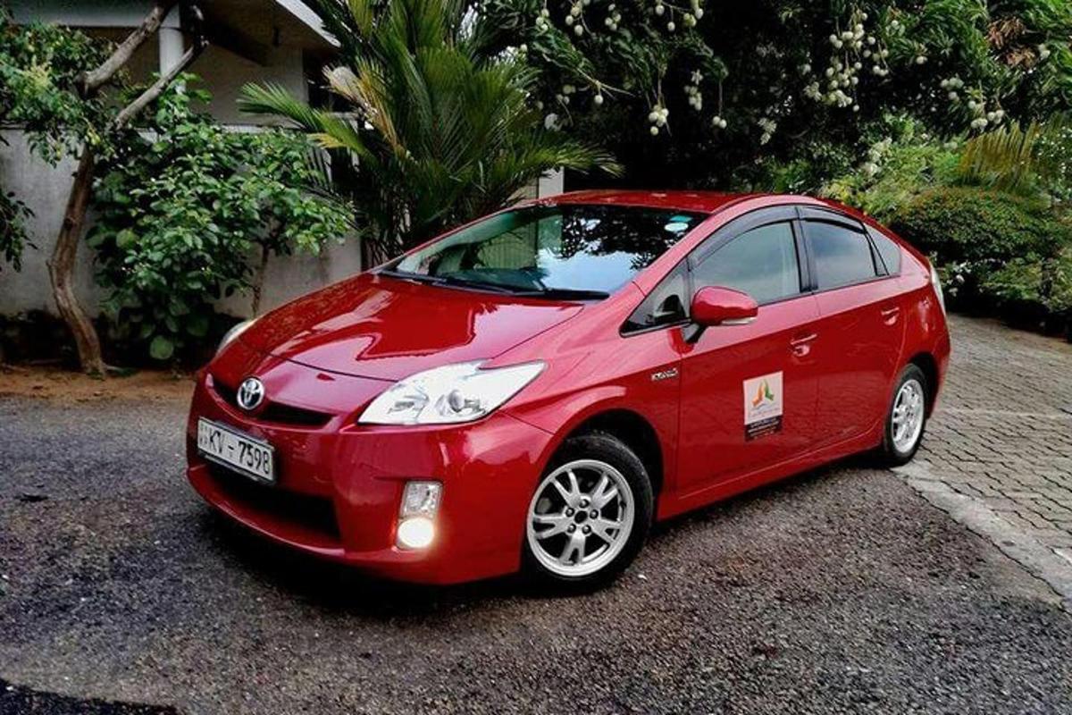 sebuah mobil merah kecil terparkir di jalan masuk