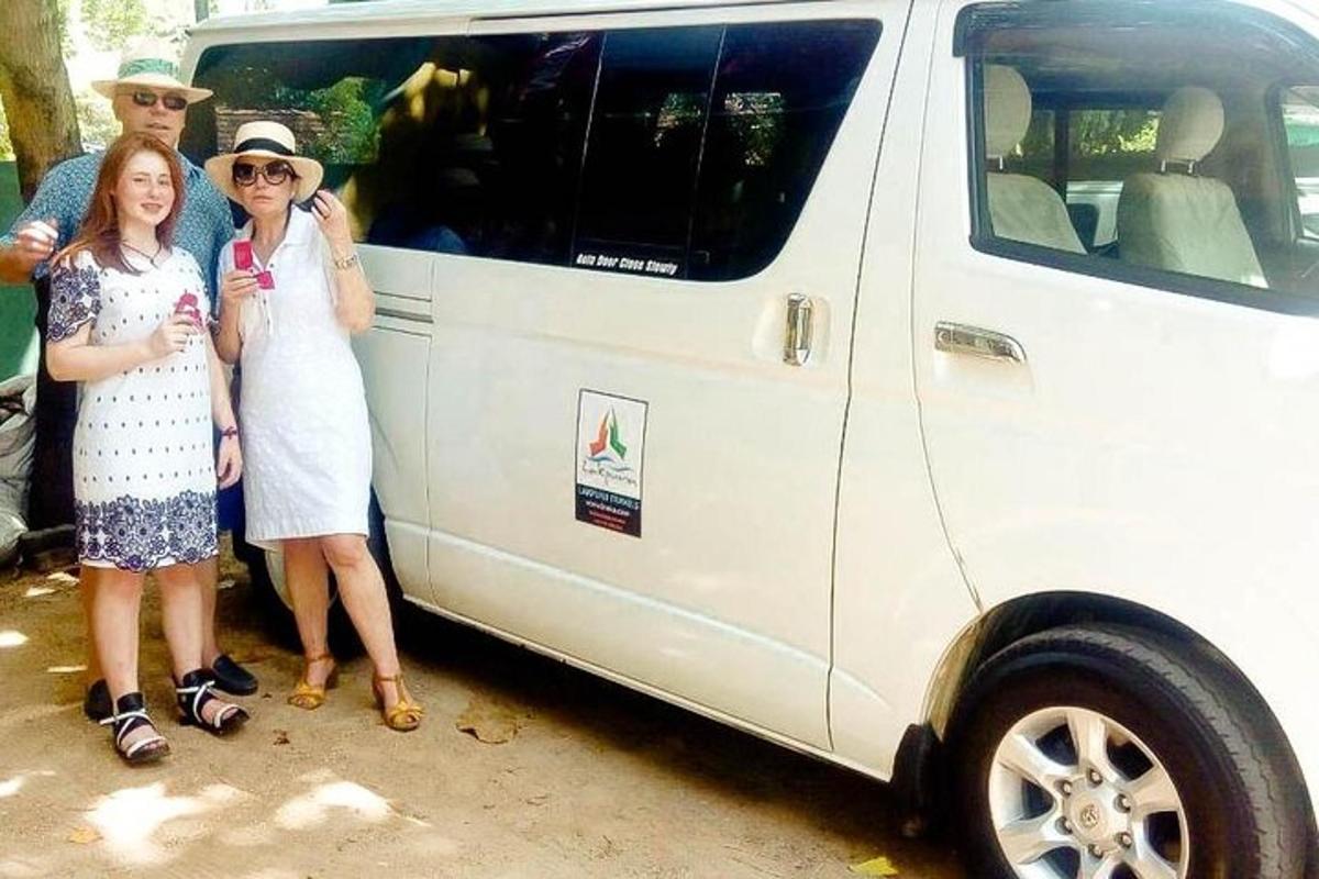 sekelompok orang berdiri di samping sebuah mobil van