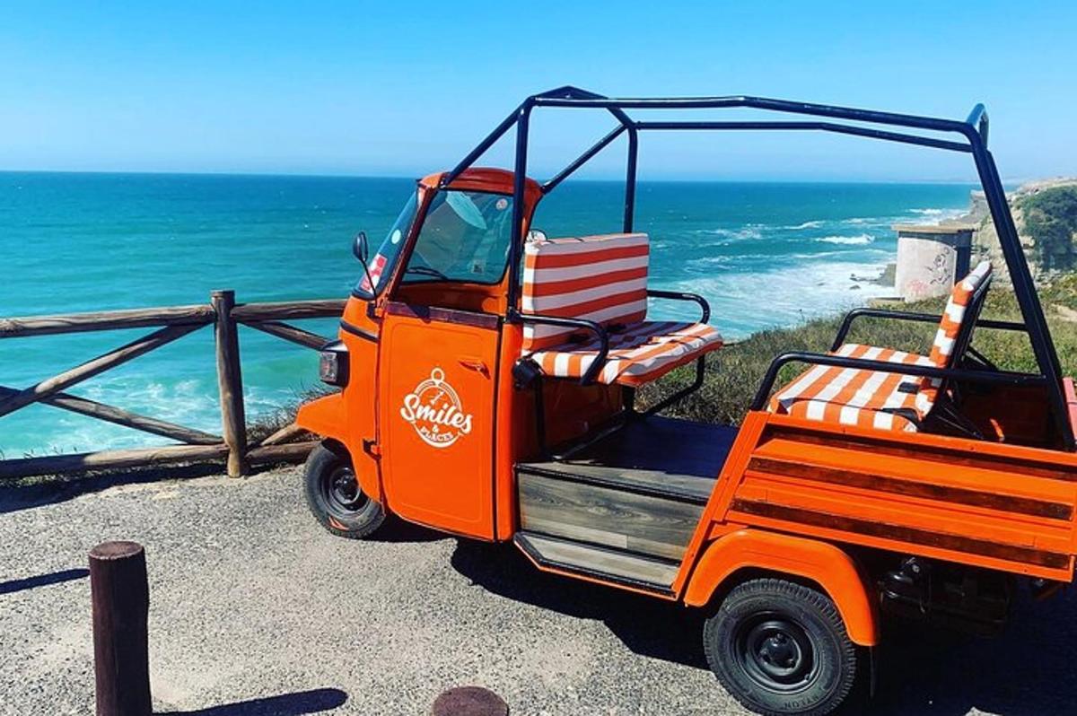 une voiturette de golf orange garée à côté de l'océan