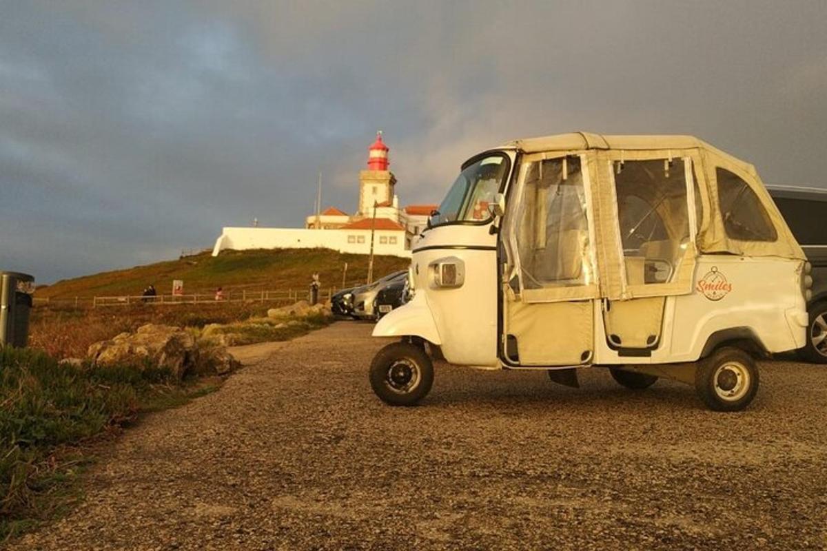 une petite voiture blanche garée devant un phare