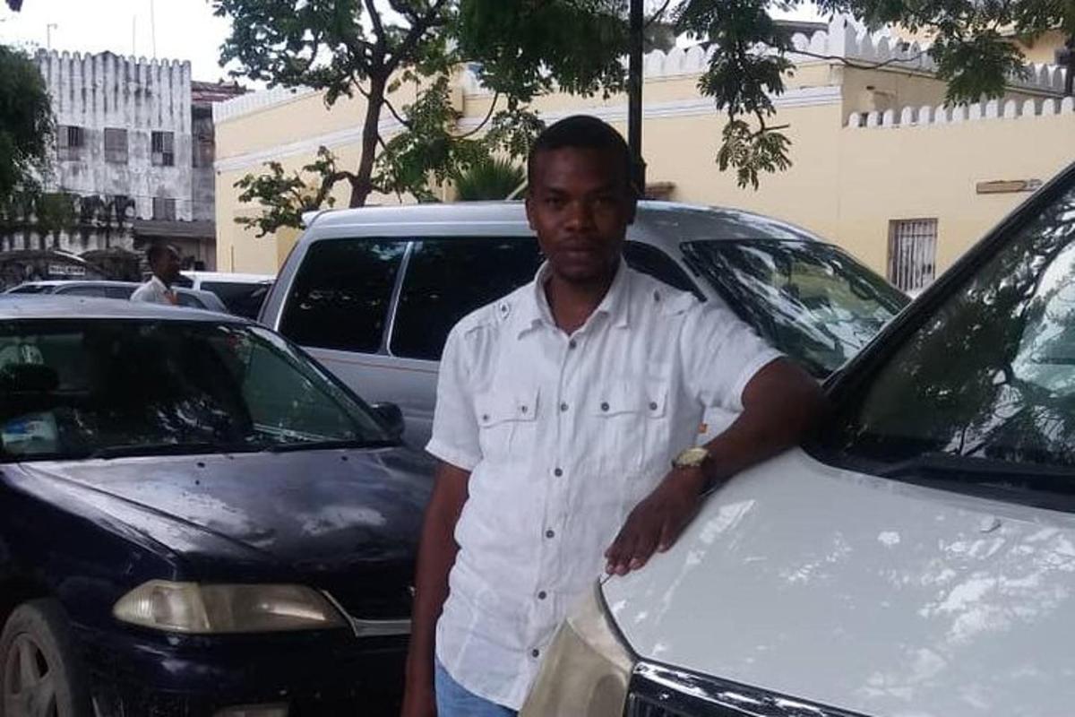 un uomo è in piedi accanto a un'auto