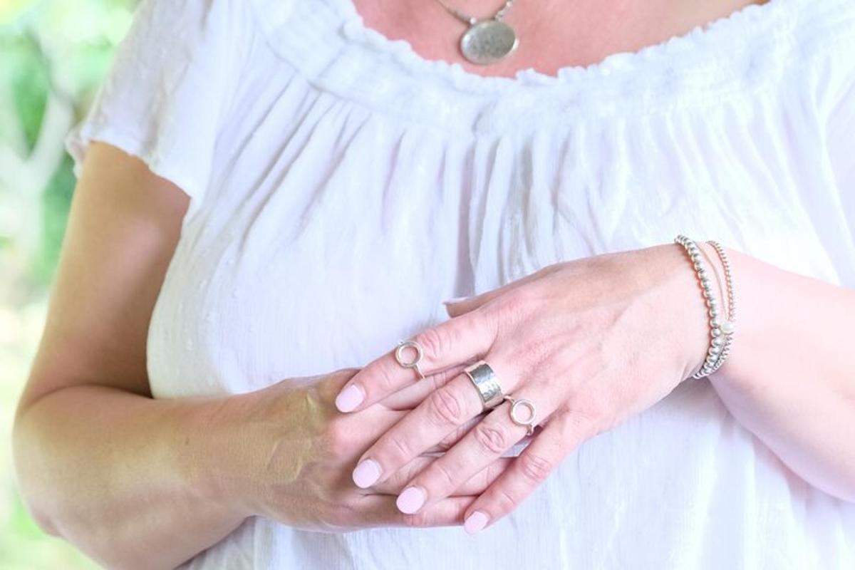 a woman wearing a white dress holding her hands