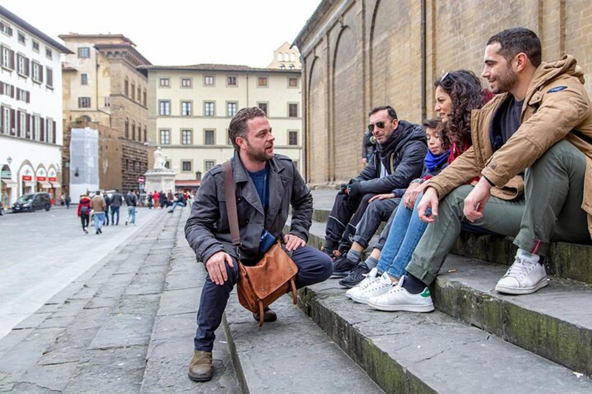 un gruppo di persone sedute sui gradini di una strada