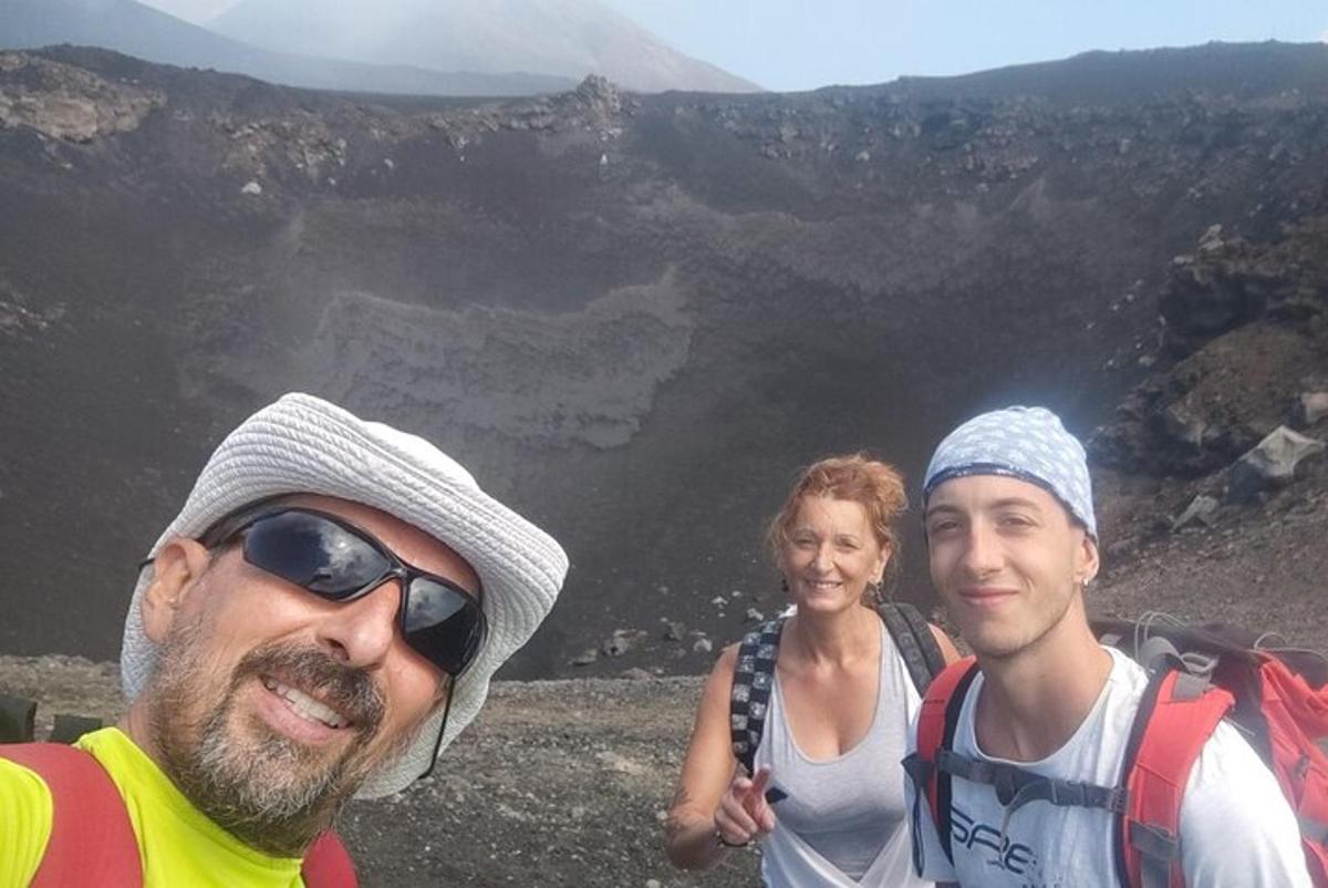 Divi vīrieši un sieviete stāv pie Lielā kanjona