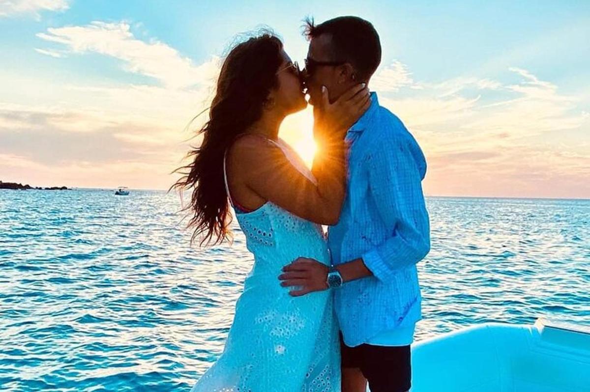 a man and woman kissing on a boat in the water