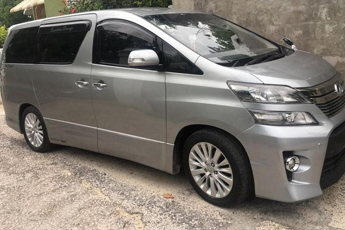uma van prateada estacionada ao lado de um prédio