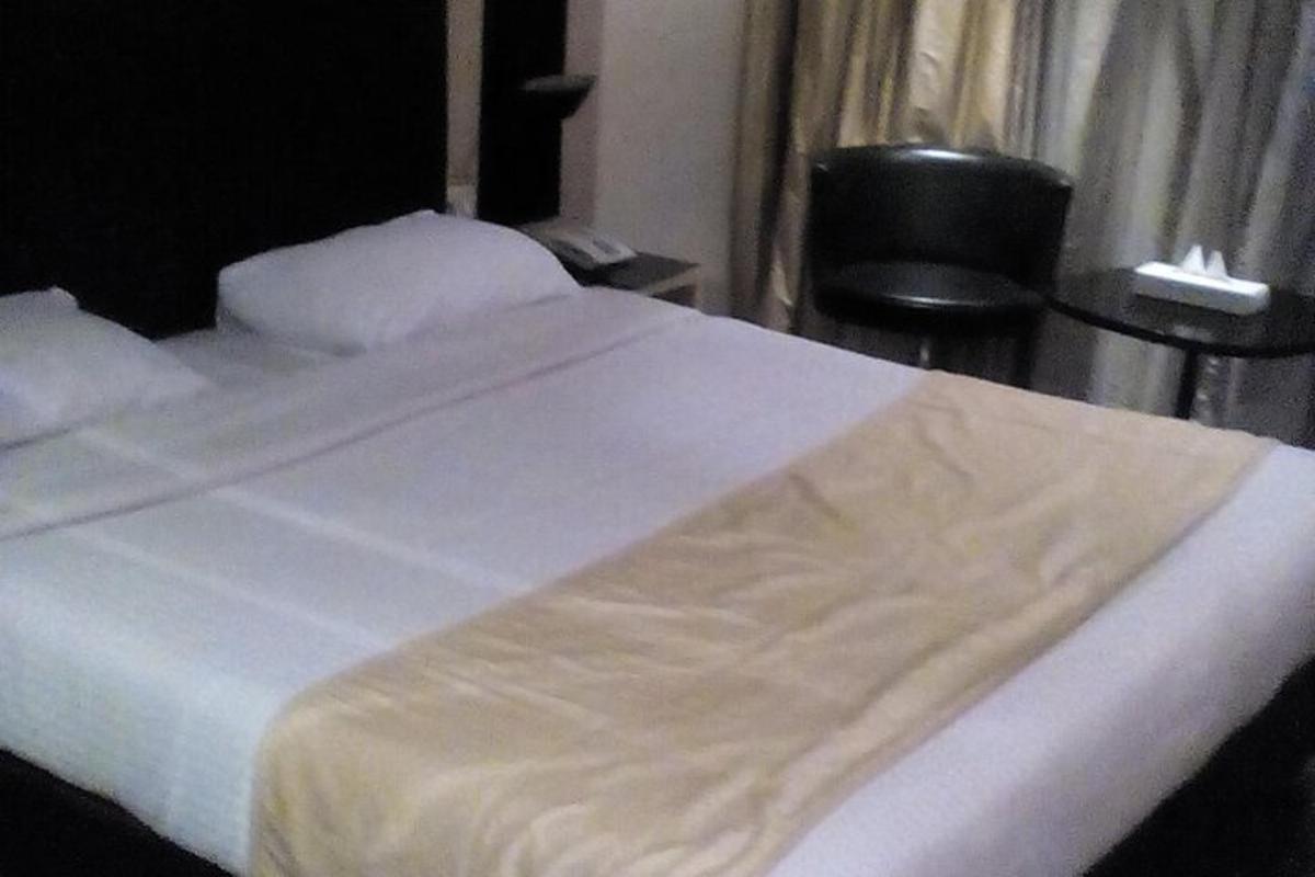 a large white bed in a room with a chair