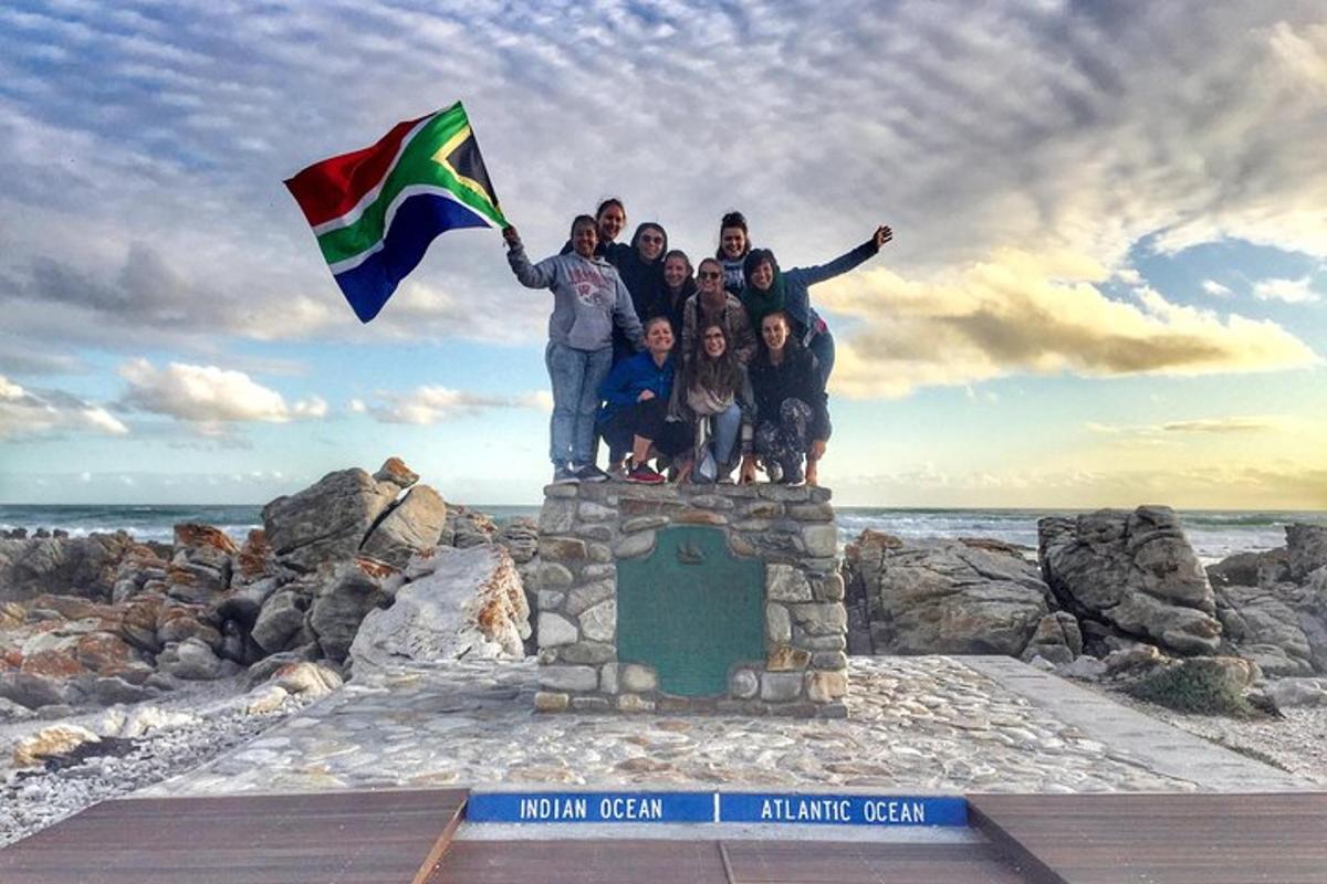 a group of people standing on a monument with a flag