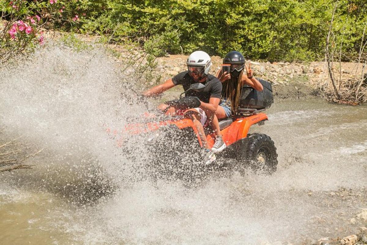 Dos personas viajando en un vehículo de cuatro ruedas en el agua.
