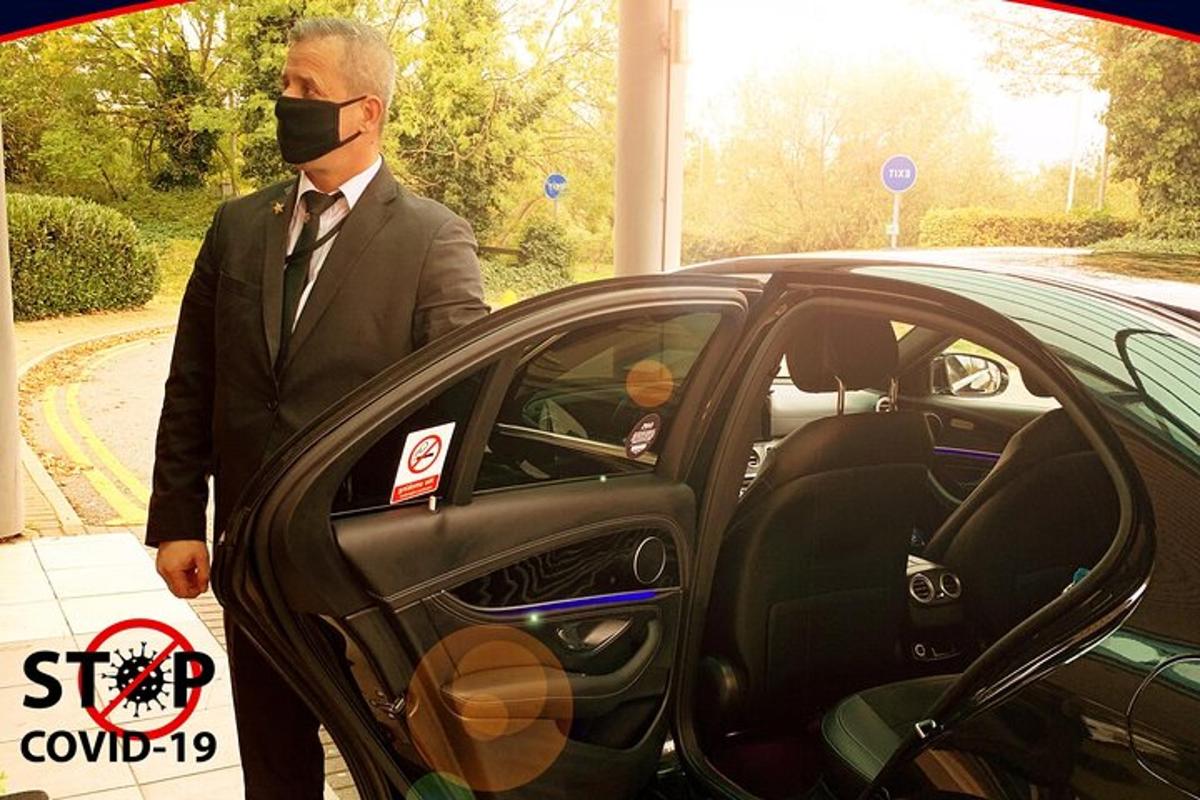 un uomo che indossa una maschera in piedi accanto a un'auto