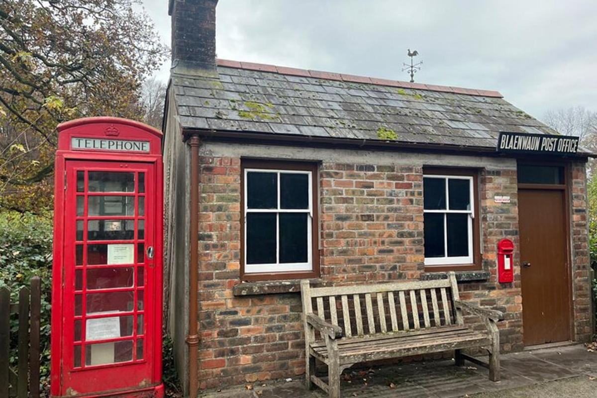a red phone booth and a bench in front of a building