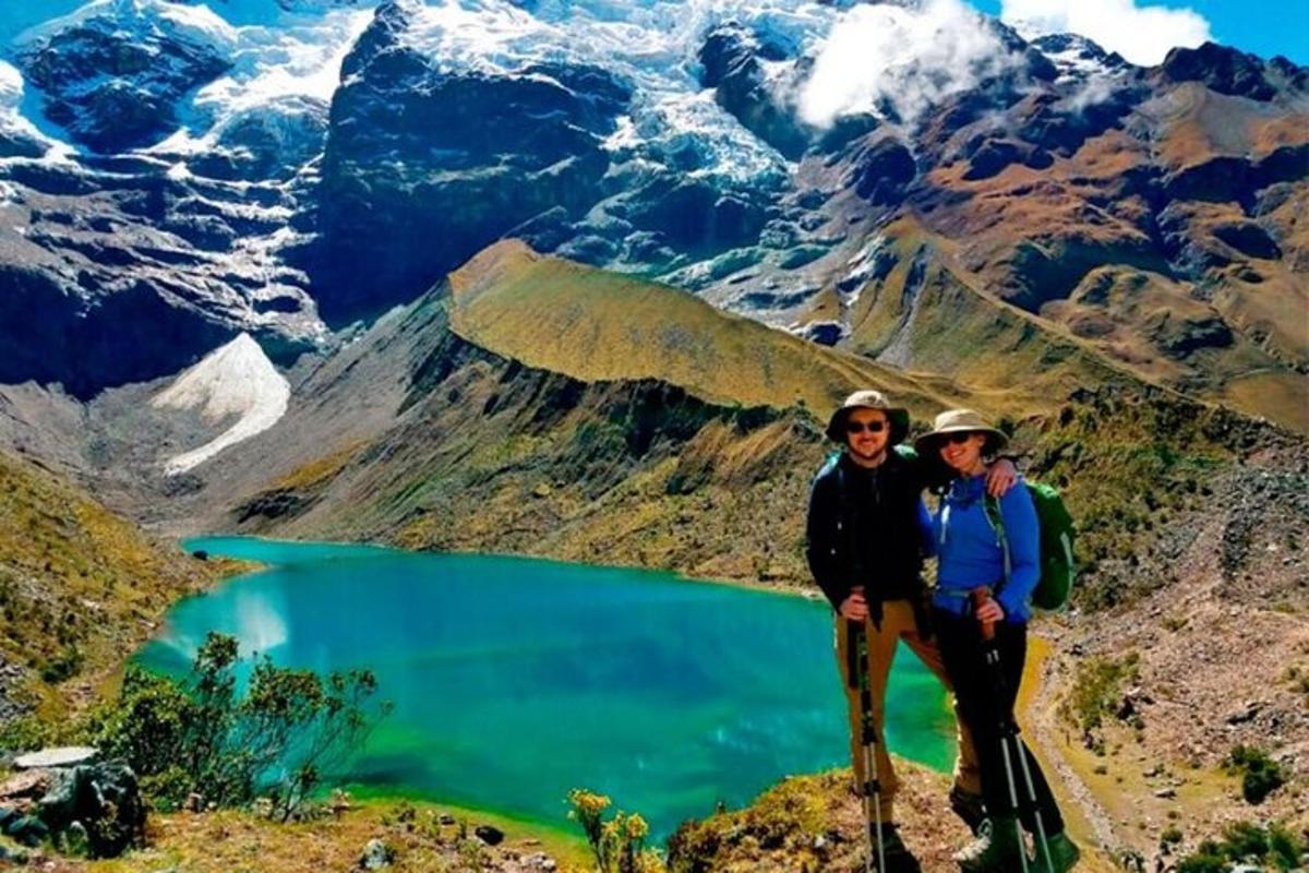 Zwei Männer stehen auf einem Berggipfel mit einem See