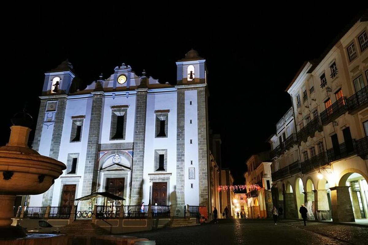 um grande edifício branco com uma torre do relógio à noite