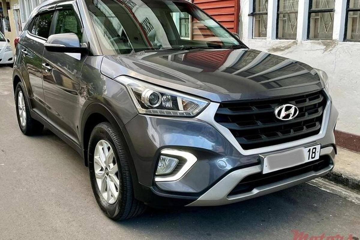 şehir caddesinde park edilmiş gümüş renkli bir SUV