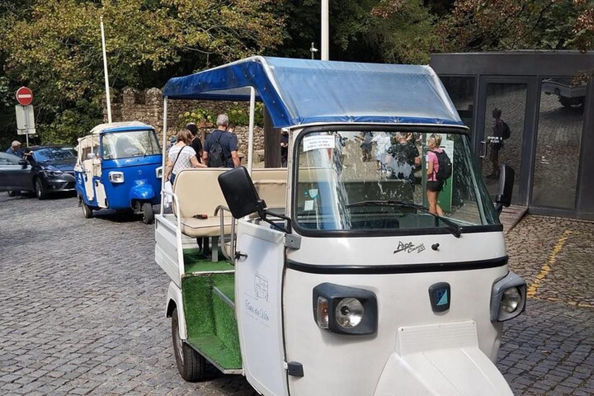 un petit véhicule avec un toit bleu dans une rue