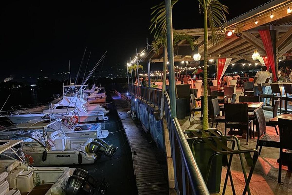 sebuah restoran dengan bot berlabuh di marina pada waktu malam
