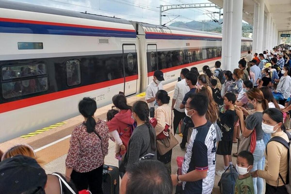 una multitud de personas esperando un tren en una estación de tren