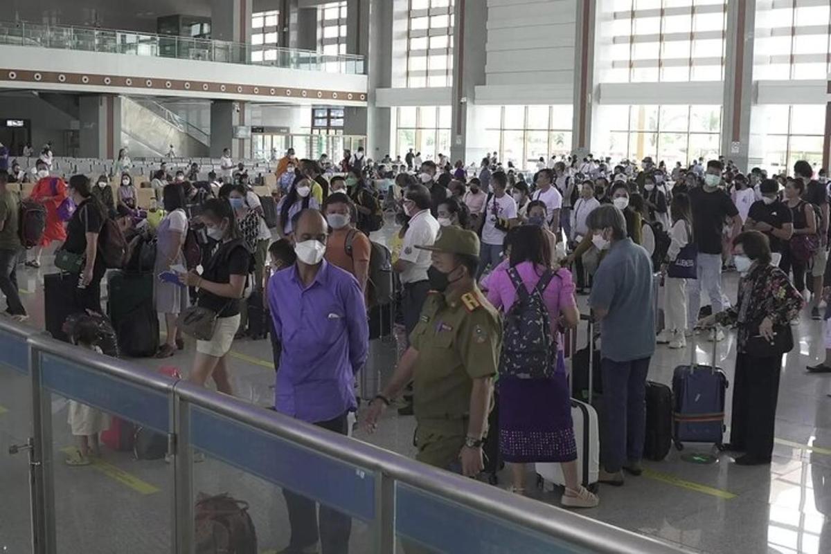 Una multitud de personas esperando su equipaje en un aeropuerto.