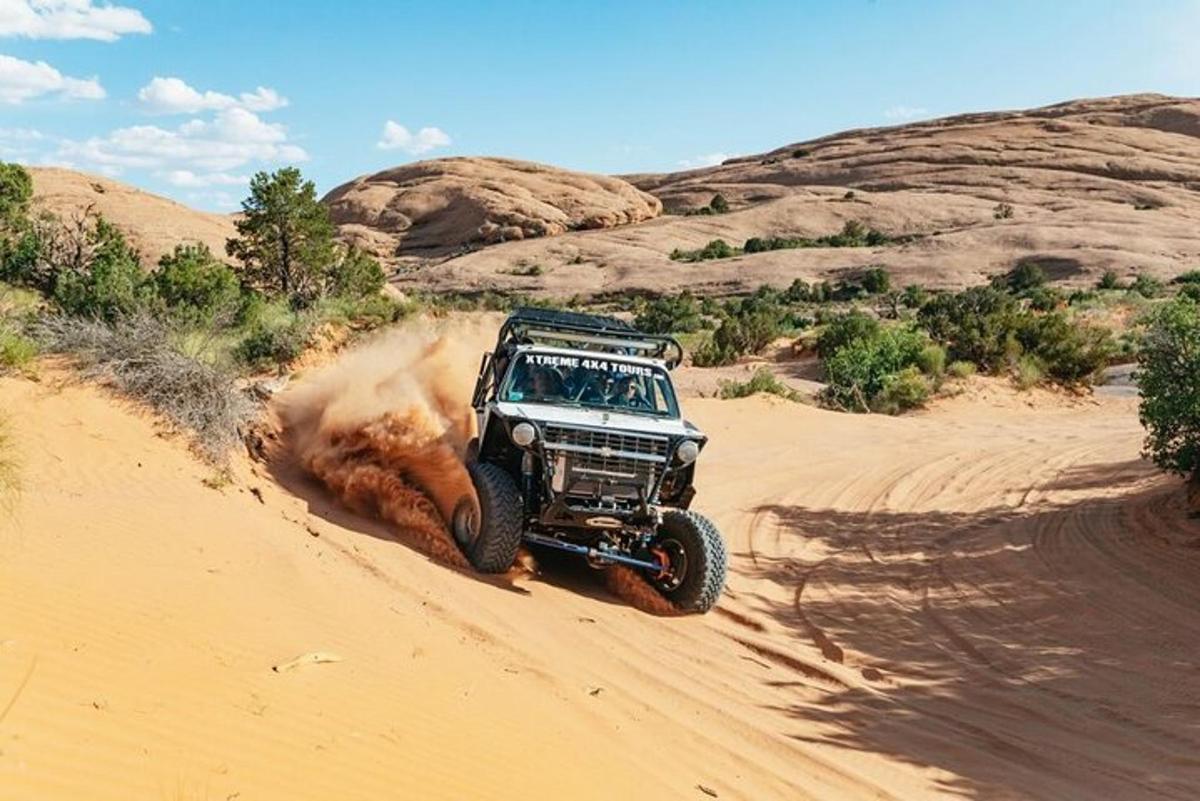 a jeep driving on the sand in the desert
