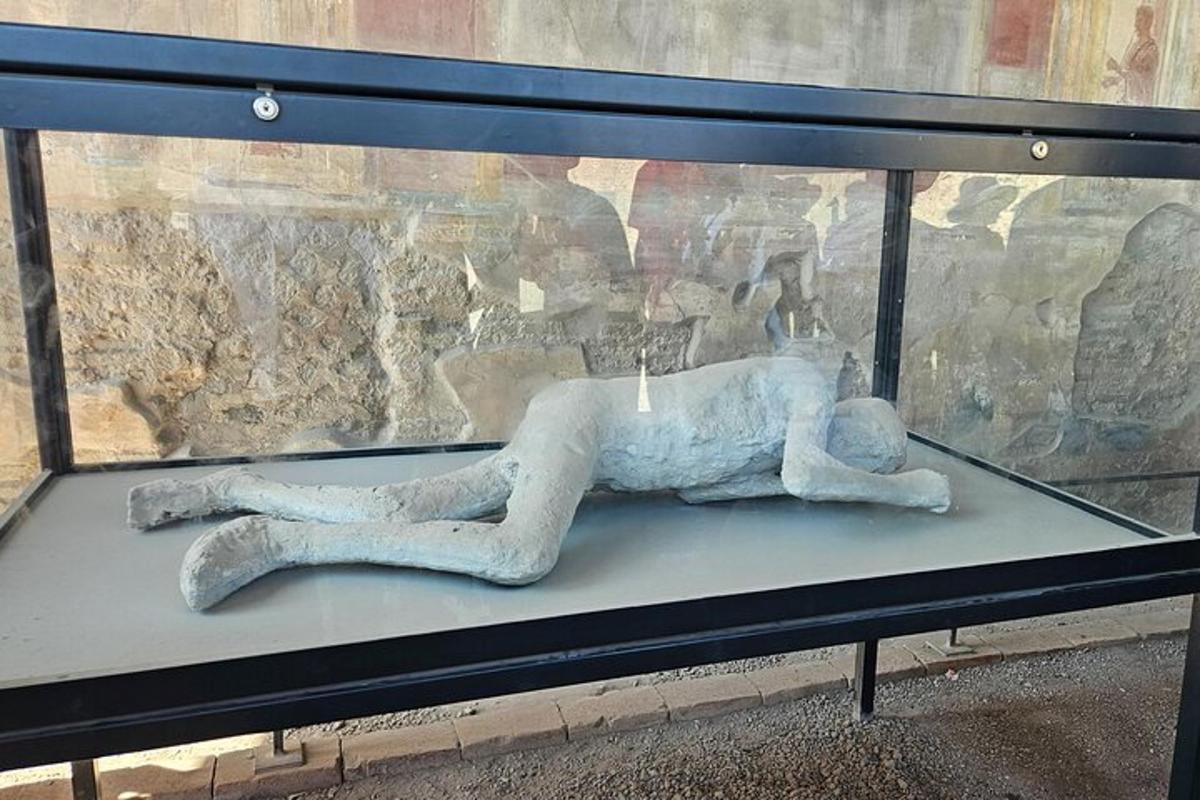 una estàtua d'una persona estirada en un banc