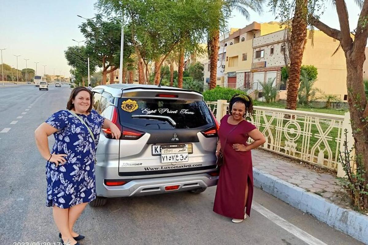 două femei stând lângă o mașină pe stradă