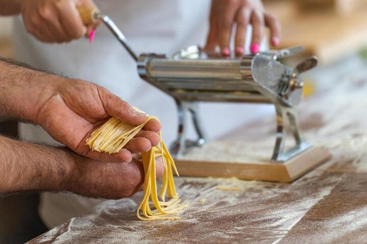 a man is using a sewing machine with pasta
