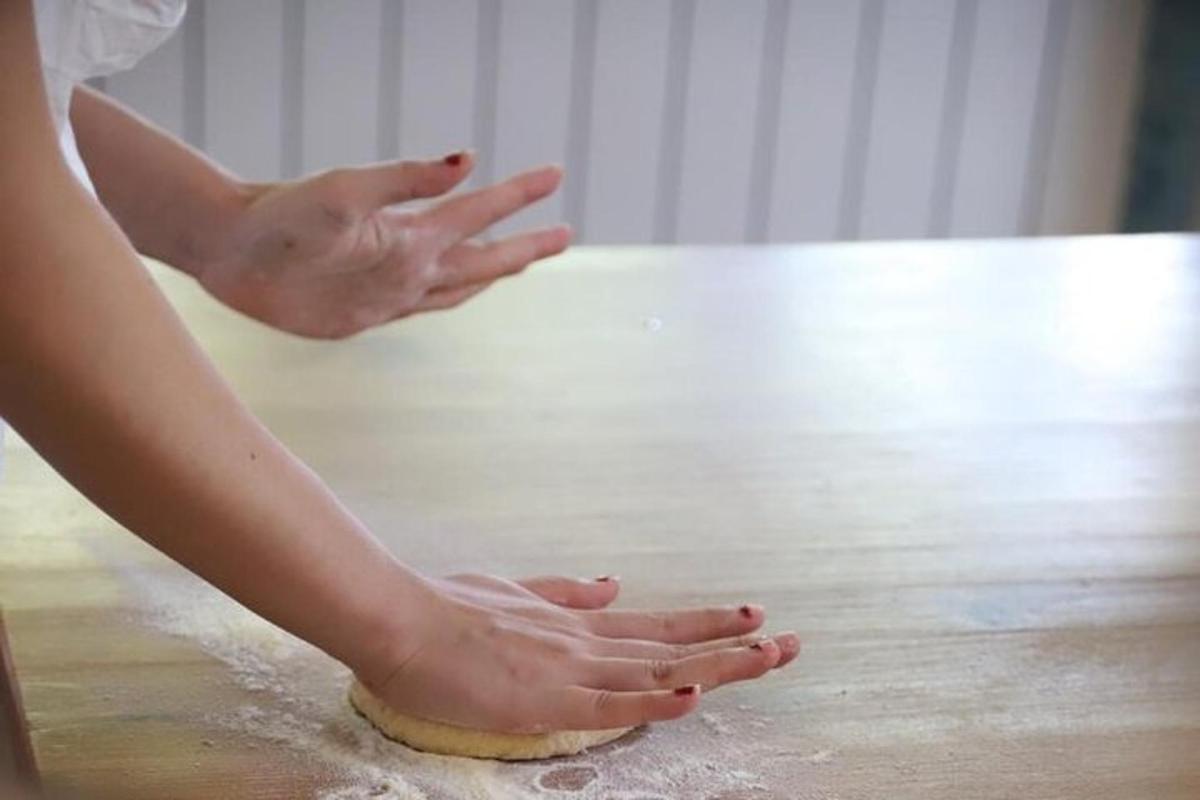 một người phụ nữ đang nhào bột trên sàn nhà