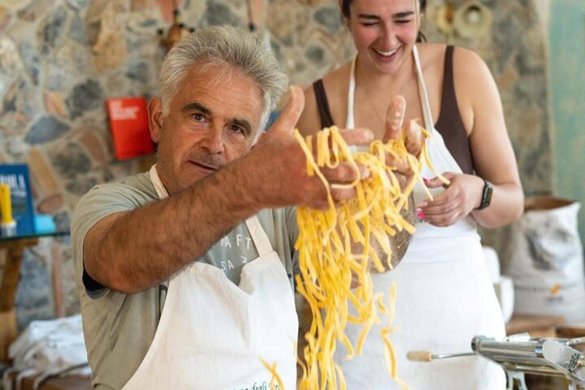 muž a žena jedí špagety v kuchyni
