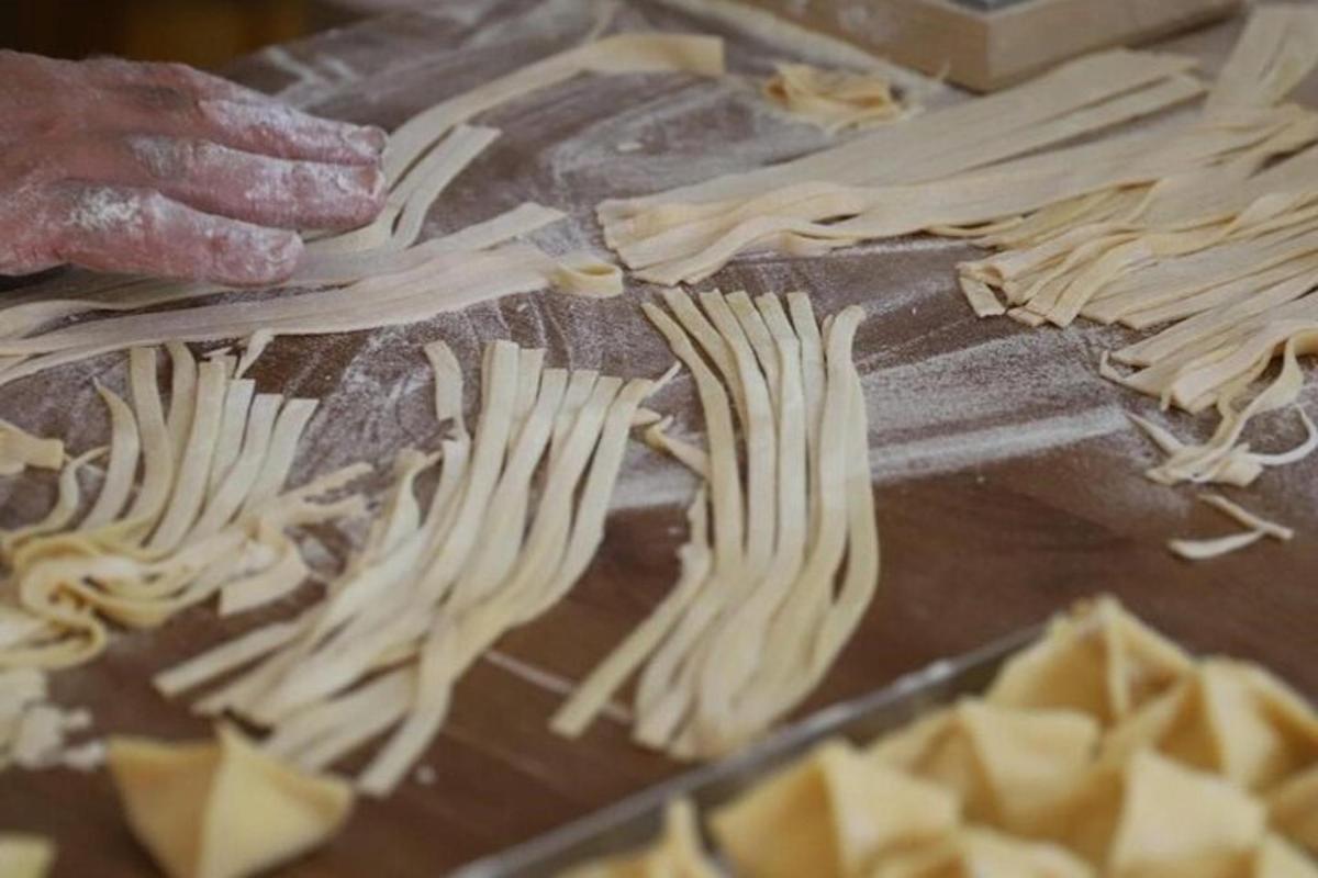 人が木製の道具を使って料理を作っている