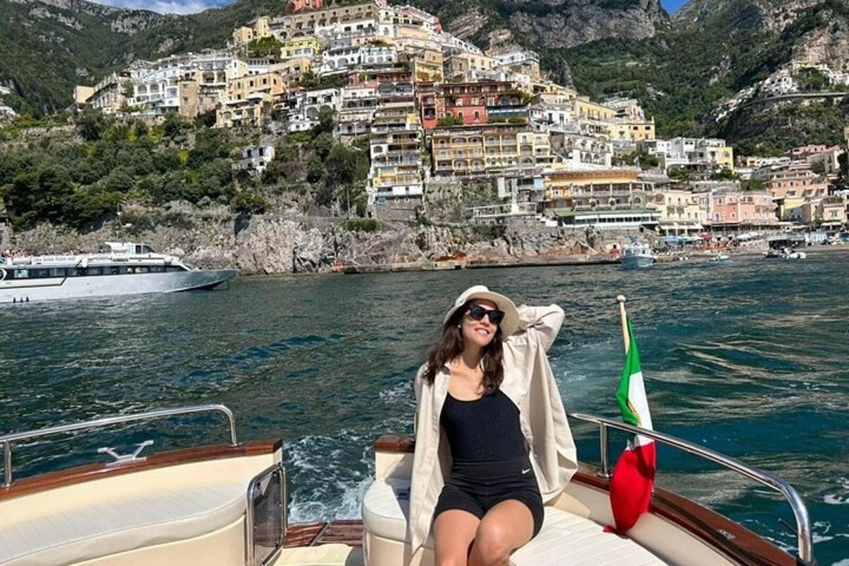 a woman sitting on the bow of a boat in the water