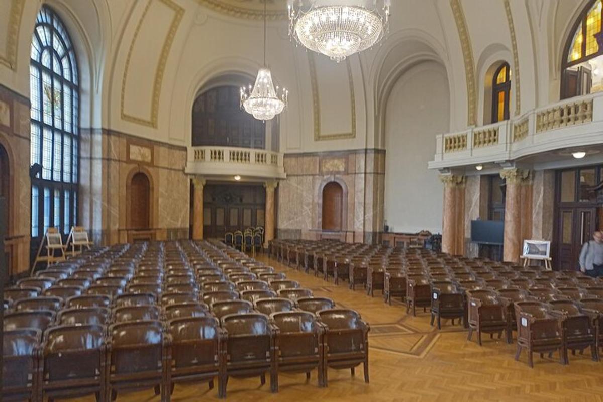 an empty lecture hall with chairs and chandeliers