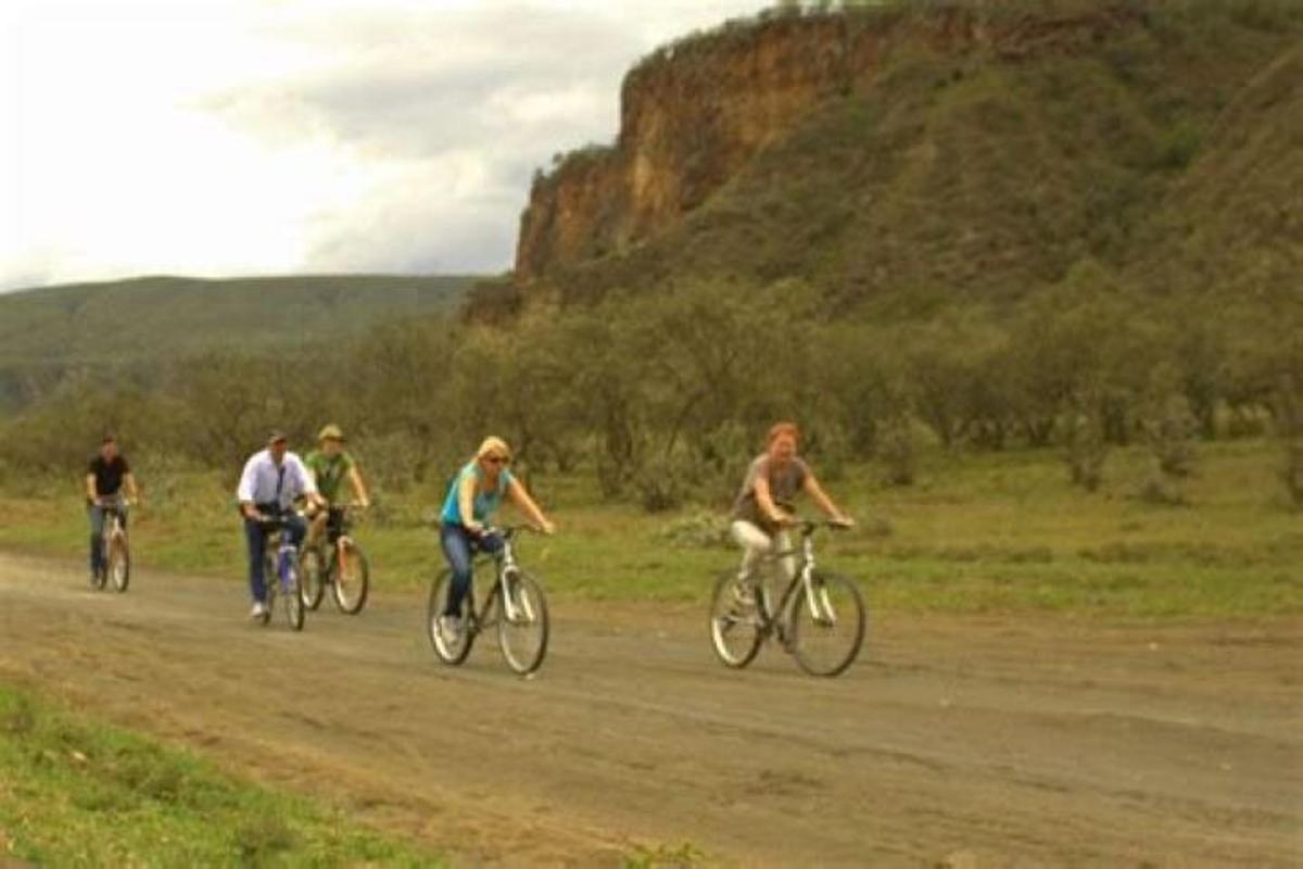 um grupo de pessoas andando de bicicleta por uma estrada de terra
