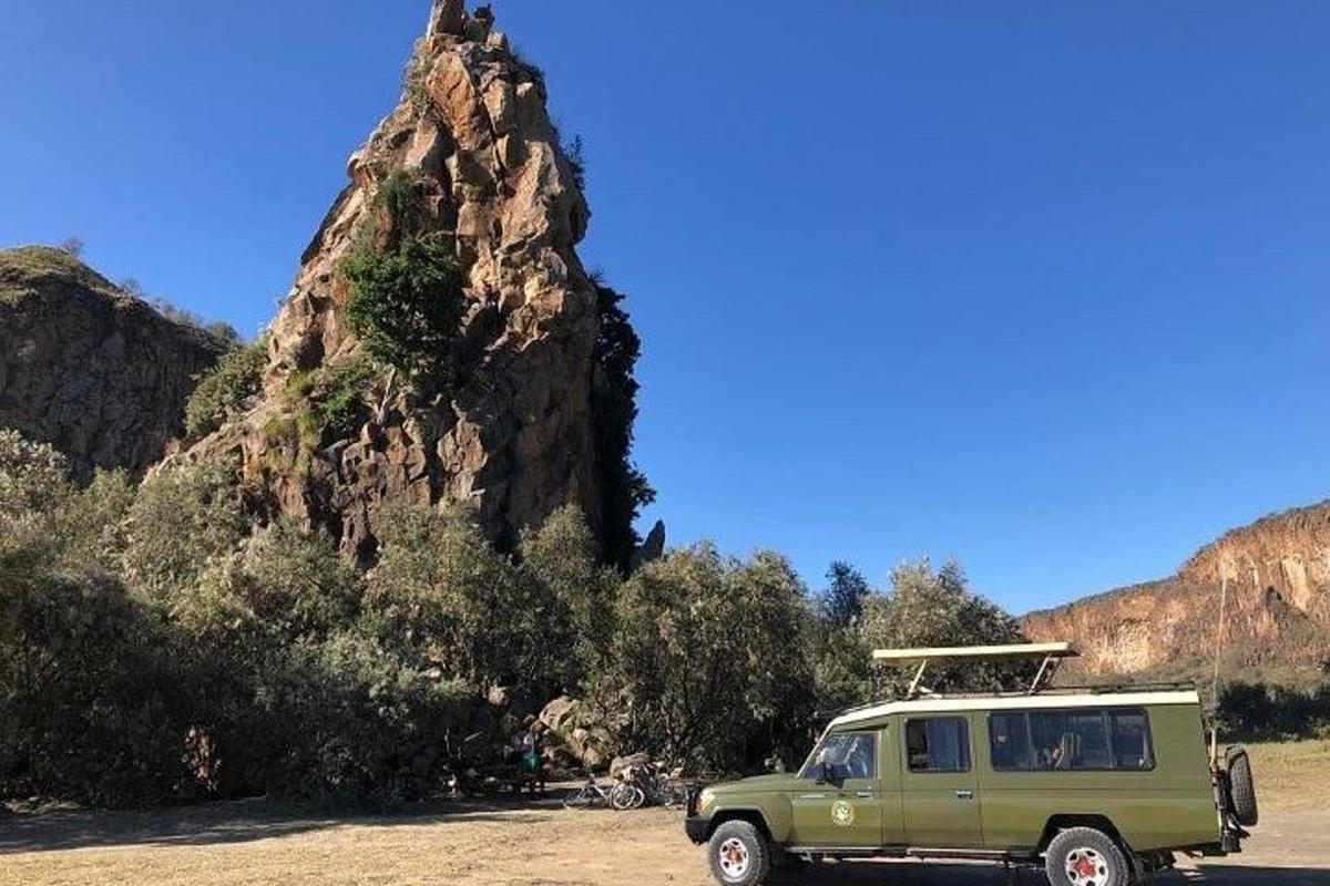 sebuah mobil van hijau terparkir di depan gunung