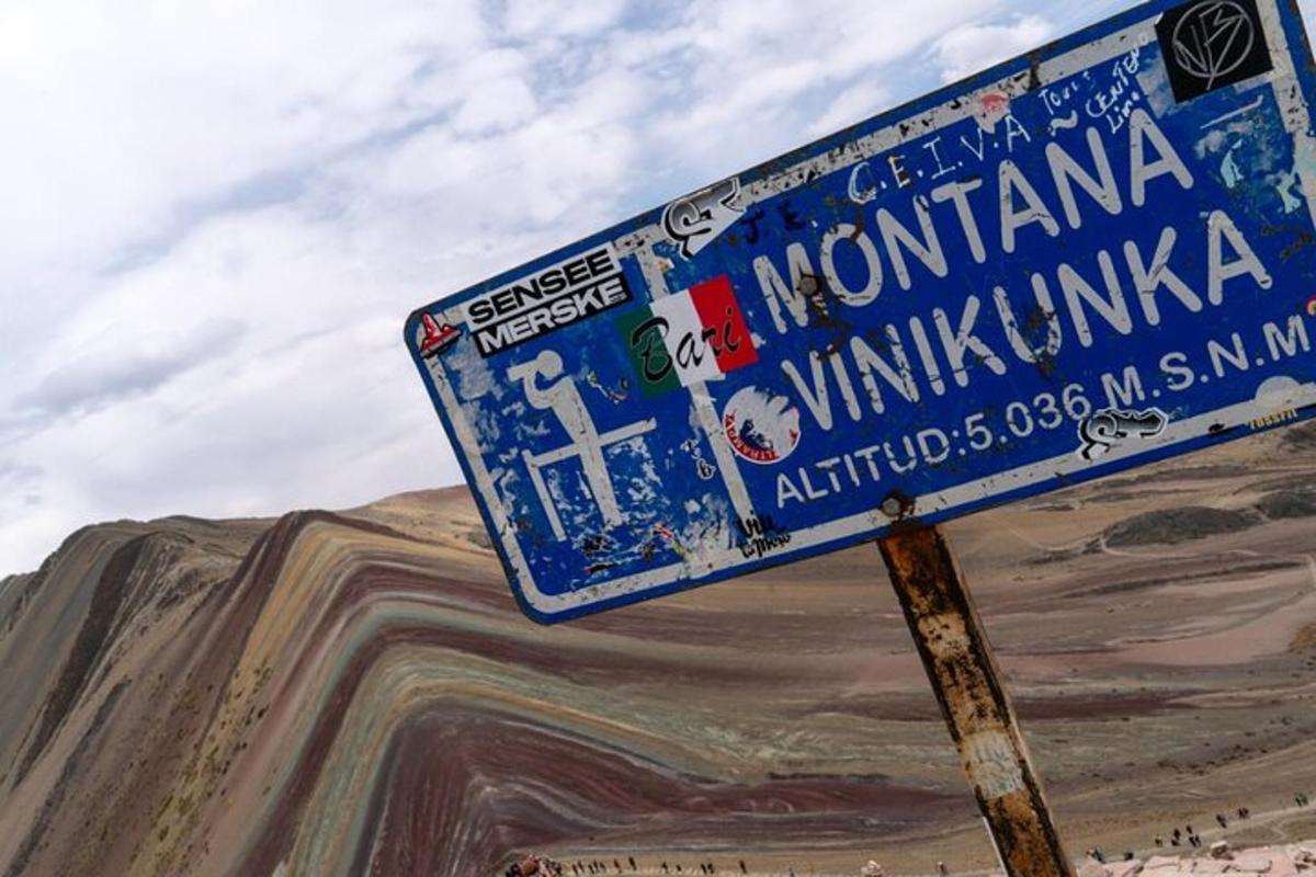 un cartello stradale blu su un palo con adesivi sopra