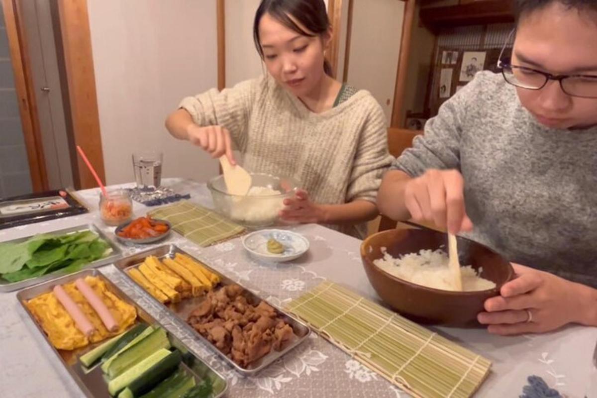 两位女士站在桌边准备食物