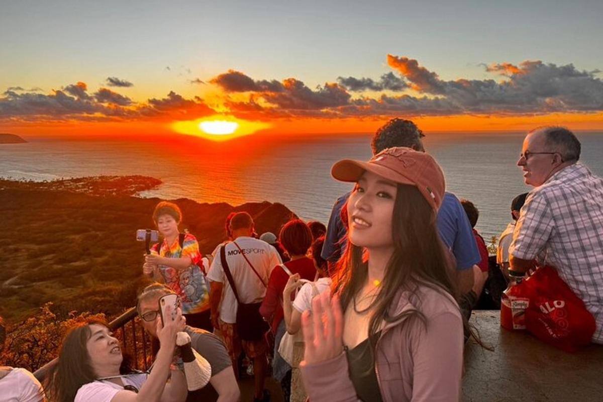 a group of people standing on a cliff watching the sunset