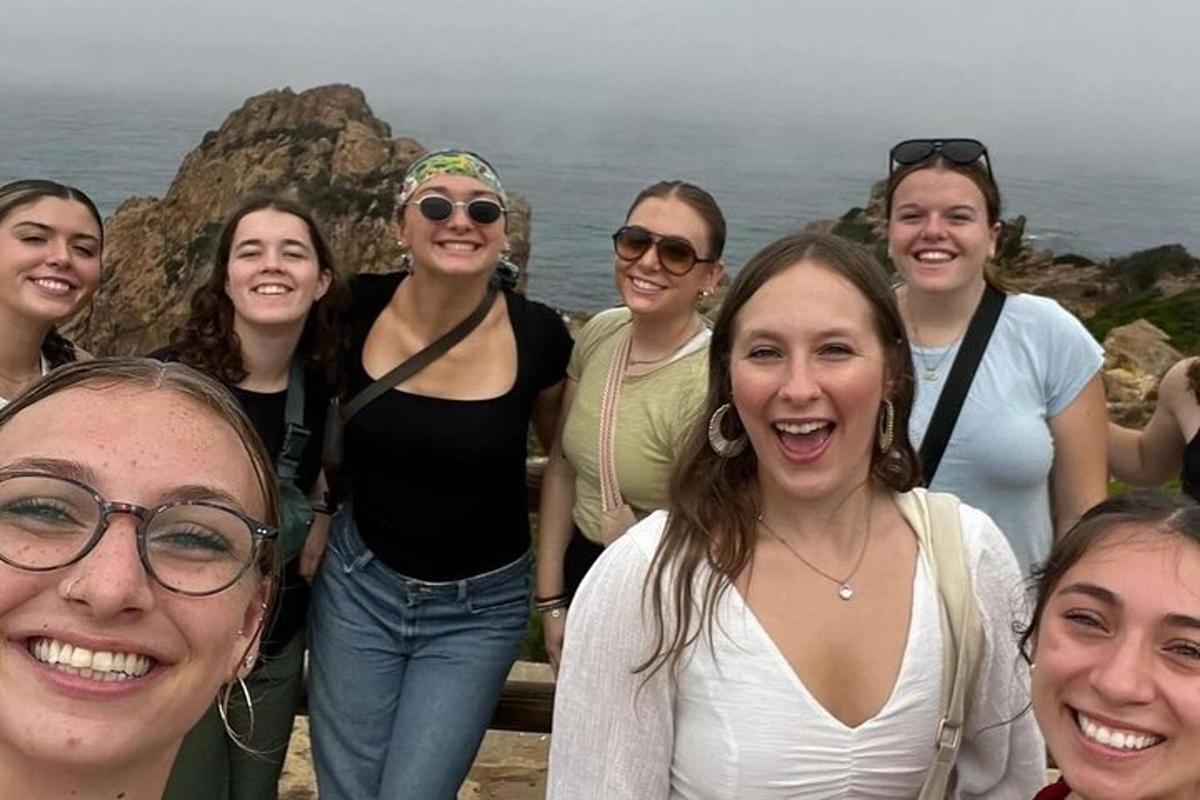 eine Gruppe von Frauen, die für ein Foto in der Nähe des Ozeans posieren