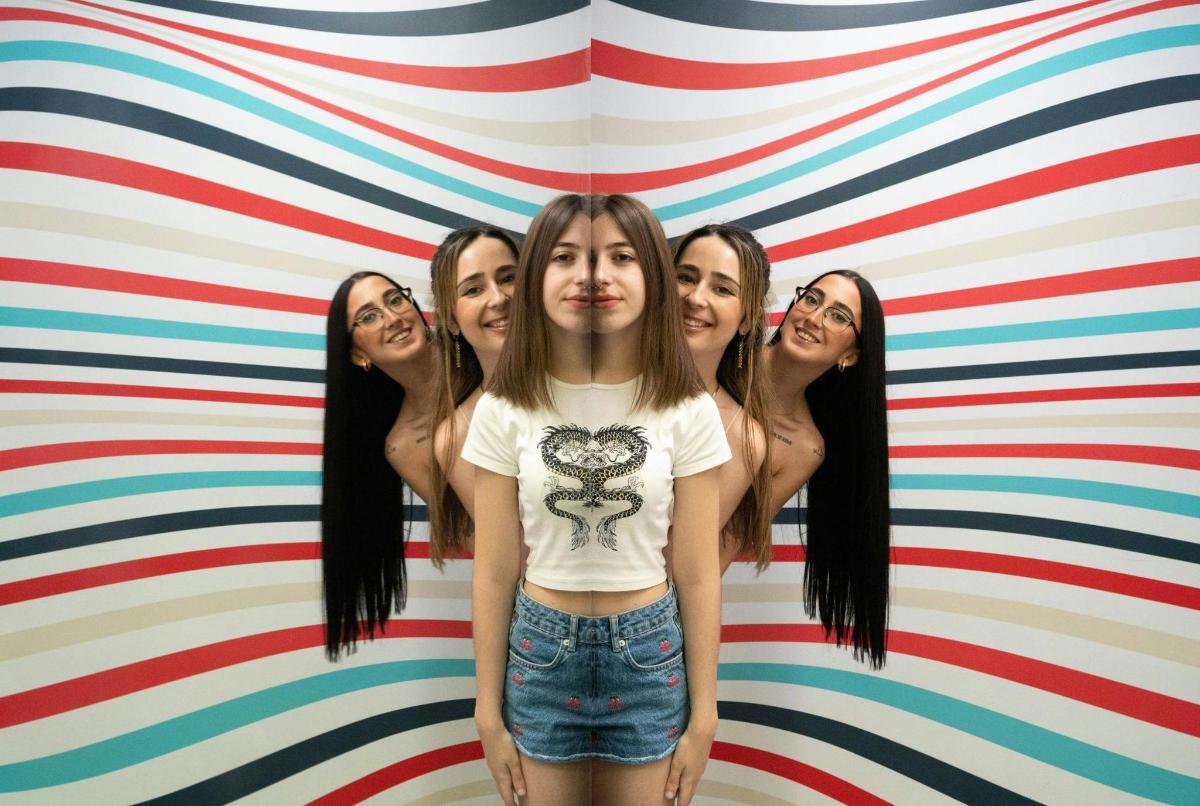 a group of girls standing in front of a wall