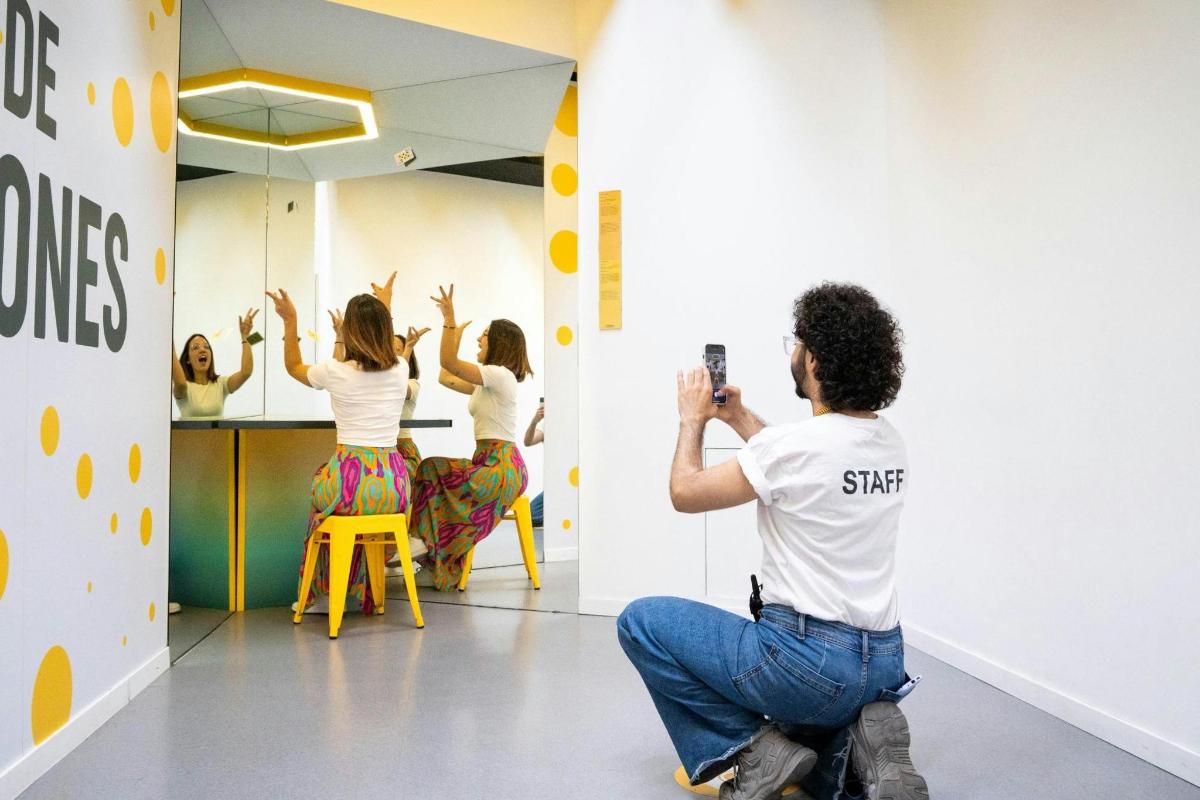 a man taking a picture of three women in a mirror