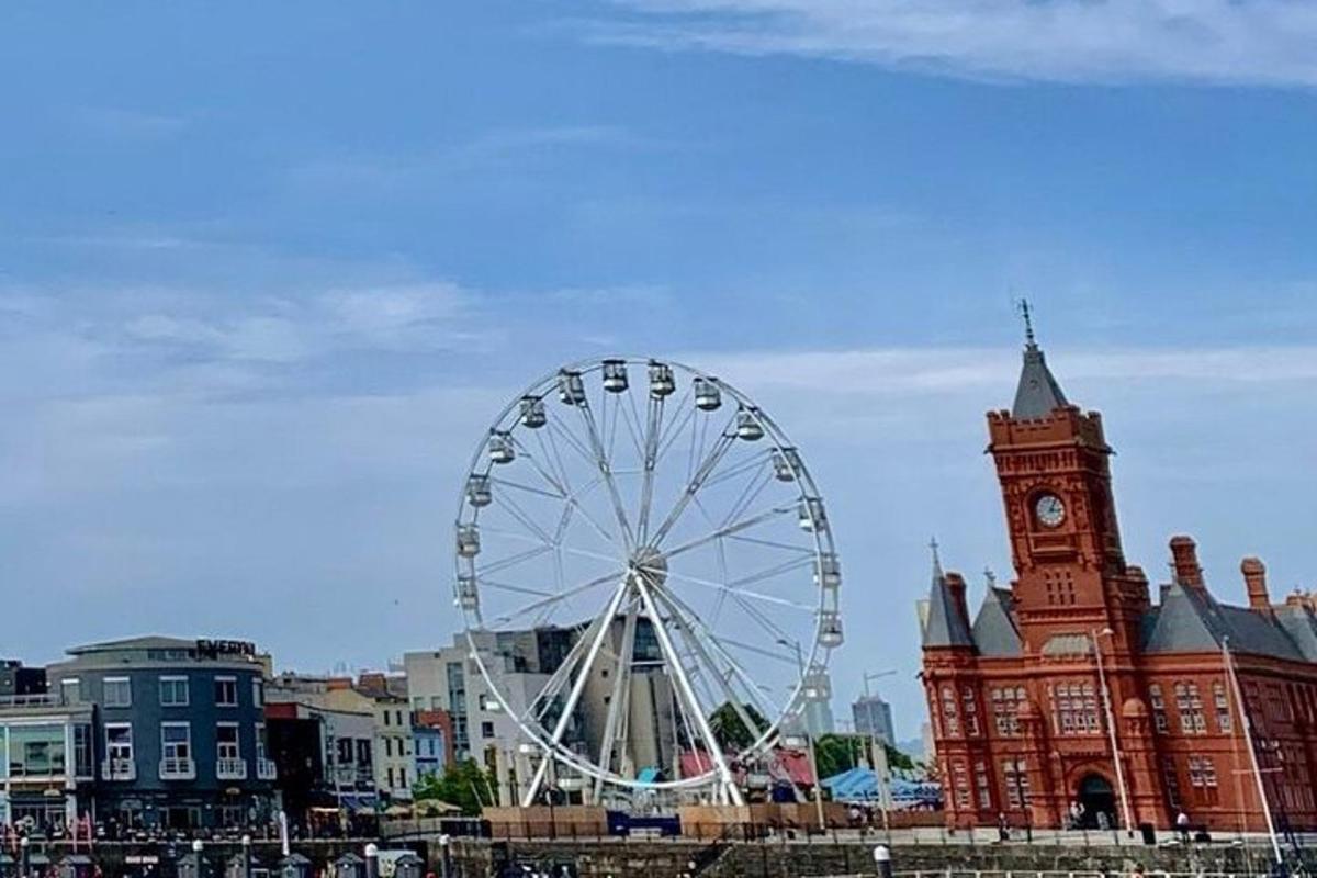 roda ferris di hadapan bangunan dengan menara jam