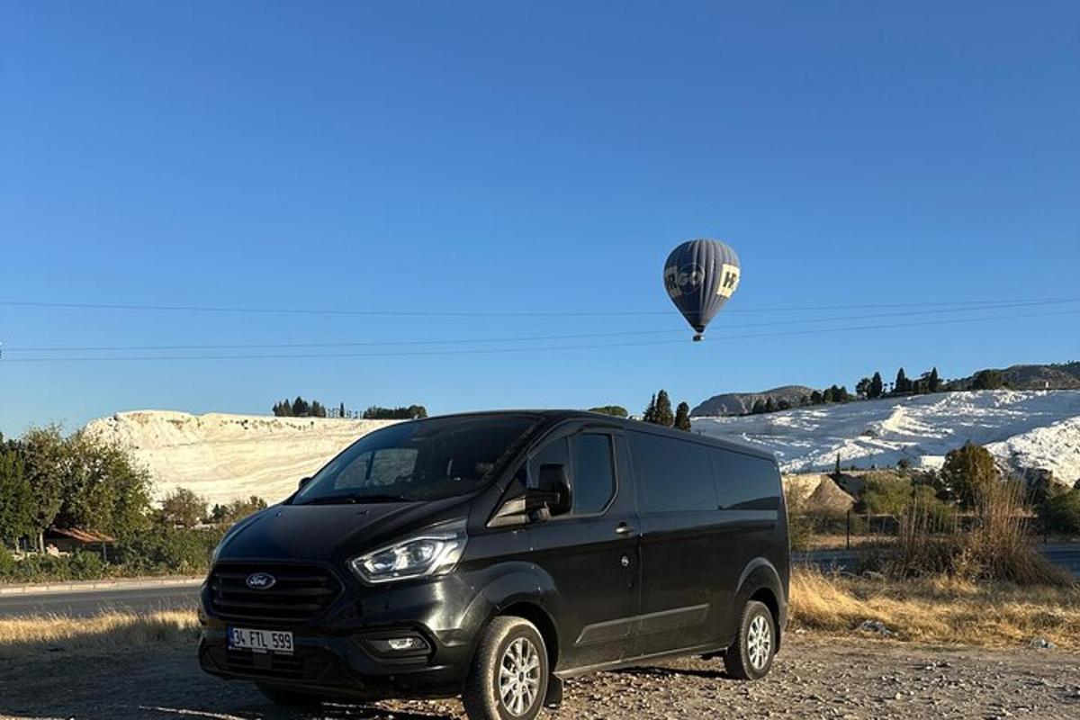 o dubă neagră parcată pe marginea drumului cu un balon cu aer cald