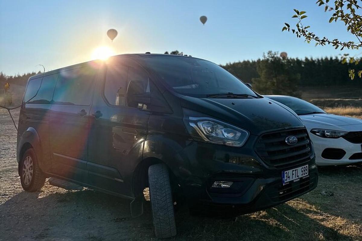o dubă neagră parcată lângă două mașini parcate