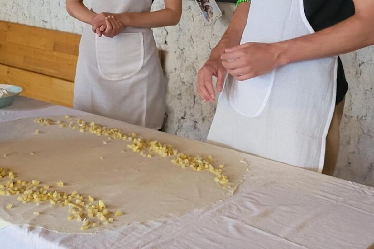 dvaja ľudia stojaci vedľa stola s jedlom na doske na krájanie
