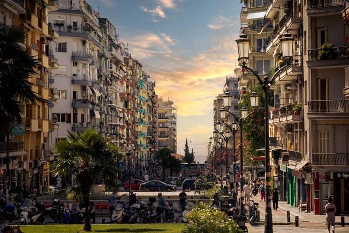uma rua da cidade com prédios altos e pessoas caminhando