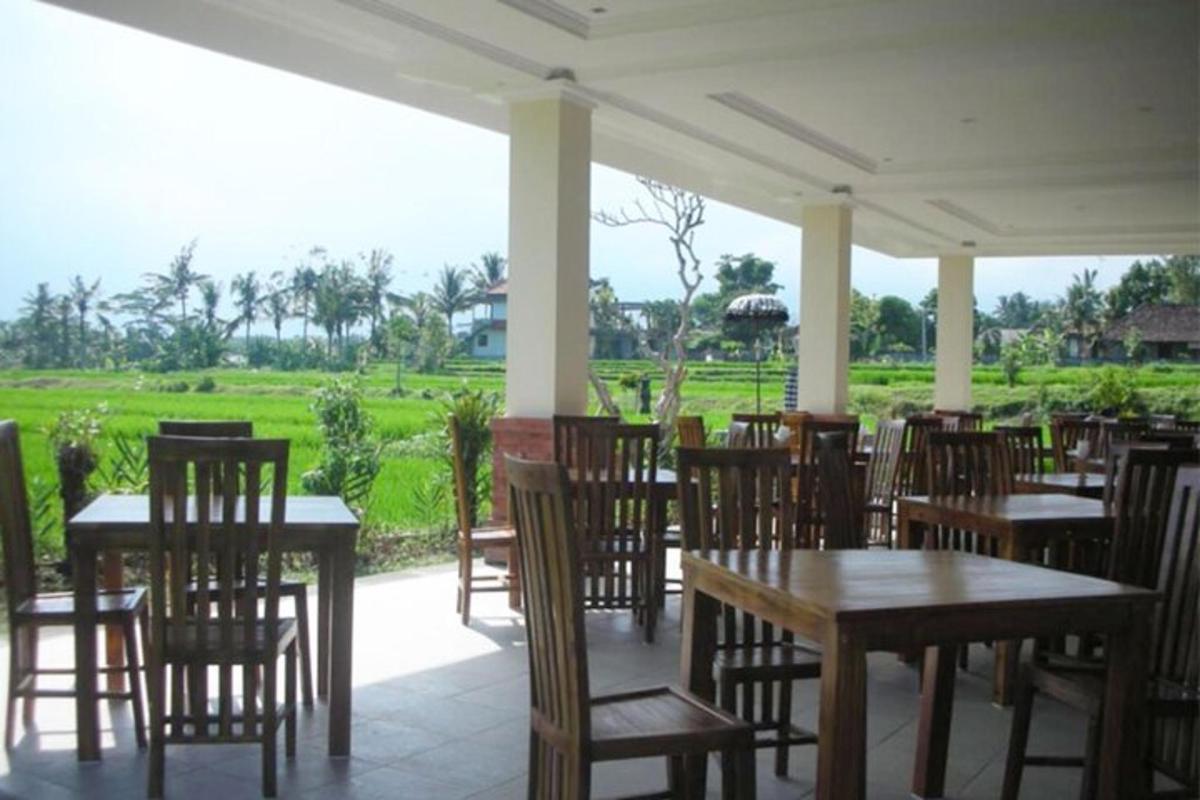 un restaurant amb taules i cadires de fusta i un camp
