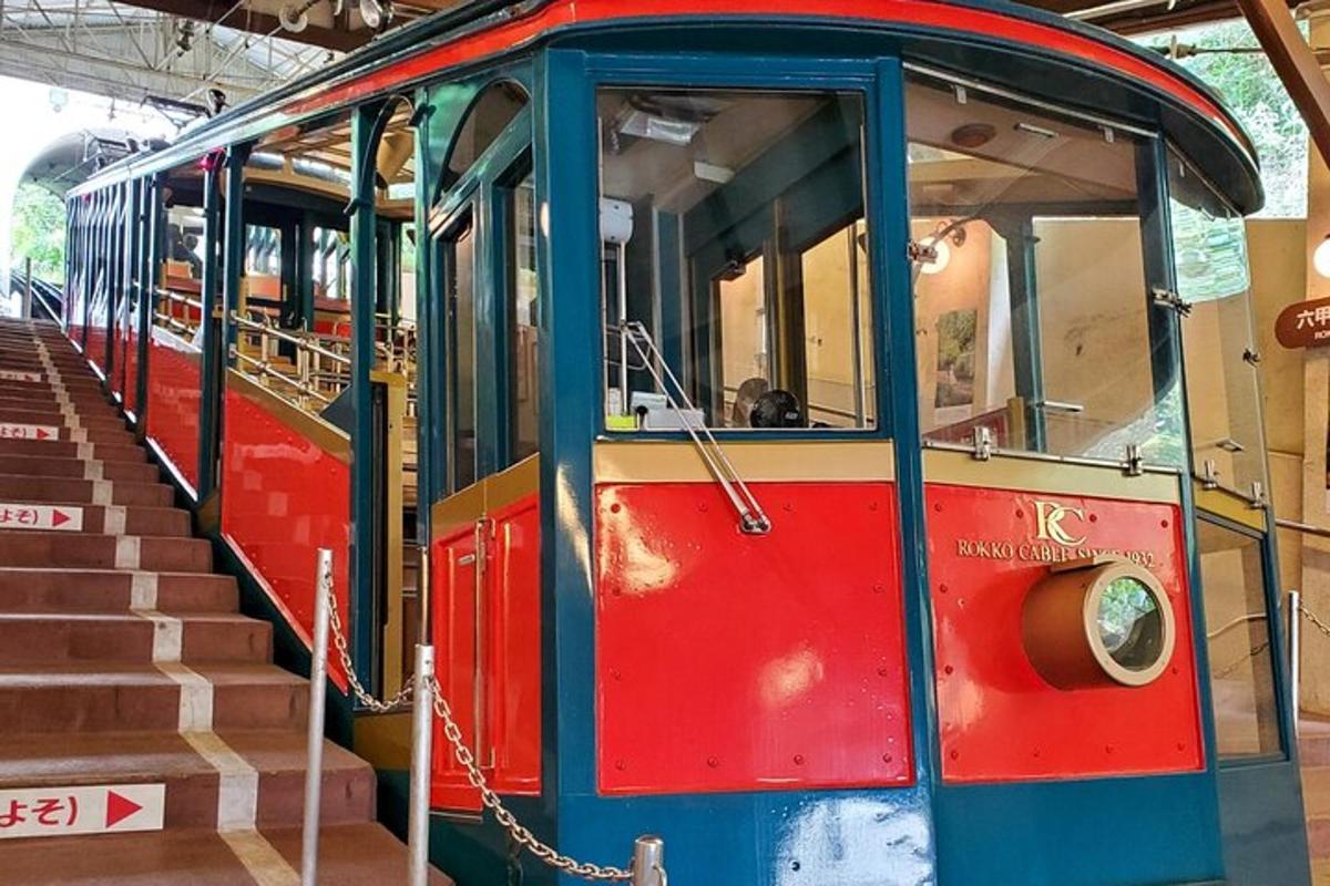 Un tren rojo y azul estacionado junto a unas escaleras.